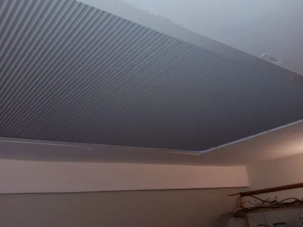 Grey pleated blinds on an attic skylight ceiling
