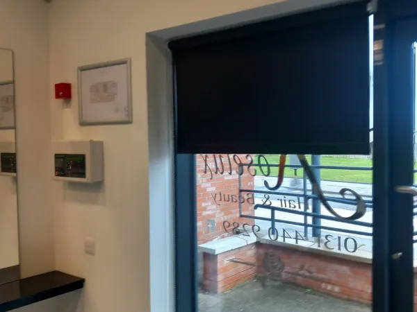 Dark roller blind on a commercial glass door