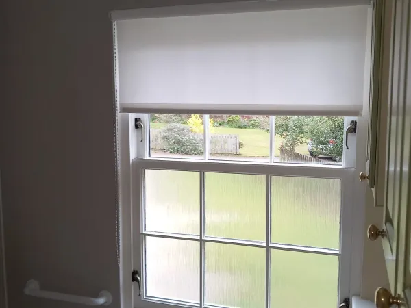 White roller blind on a bathroom sash window