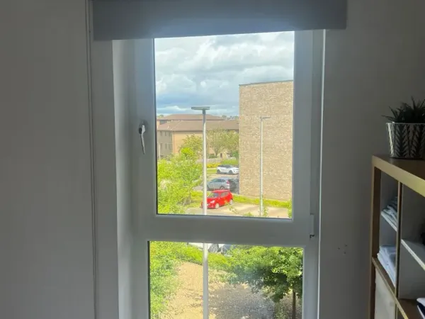 Roller blind raised above an Edinburgh bedroom window showing the clean fit