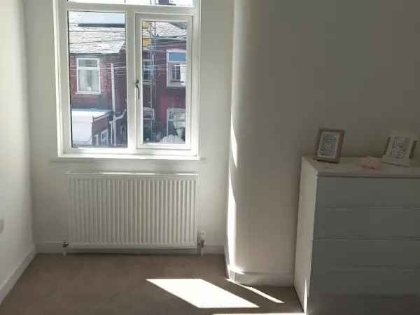 White roller blind fitted in an Edinburgh bedroom window for blackout light control