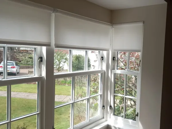 White roller blinds professionally fitted on sash bay windows in an Edinburgh home